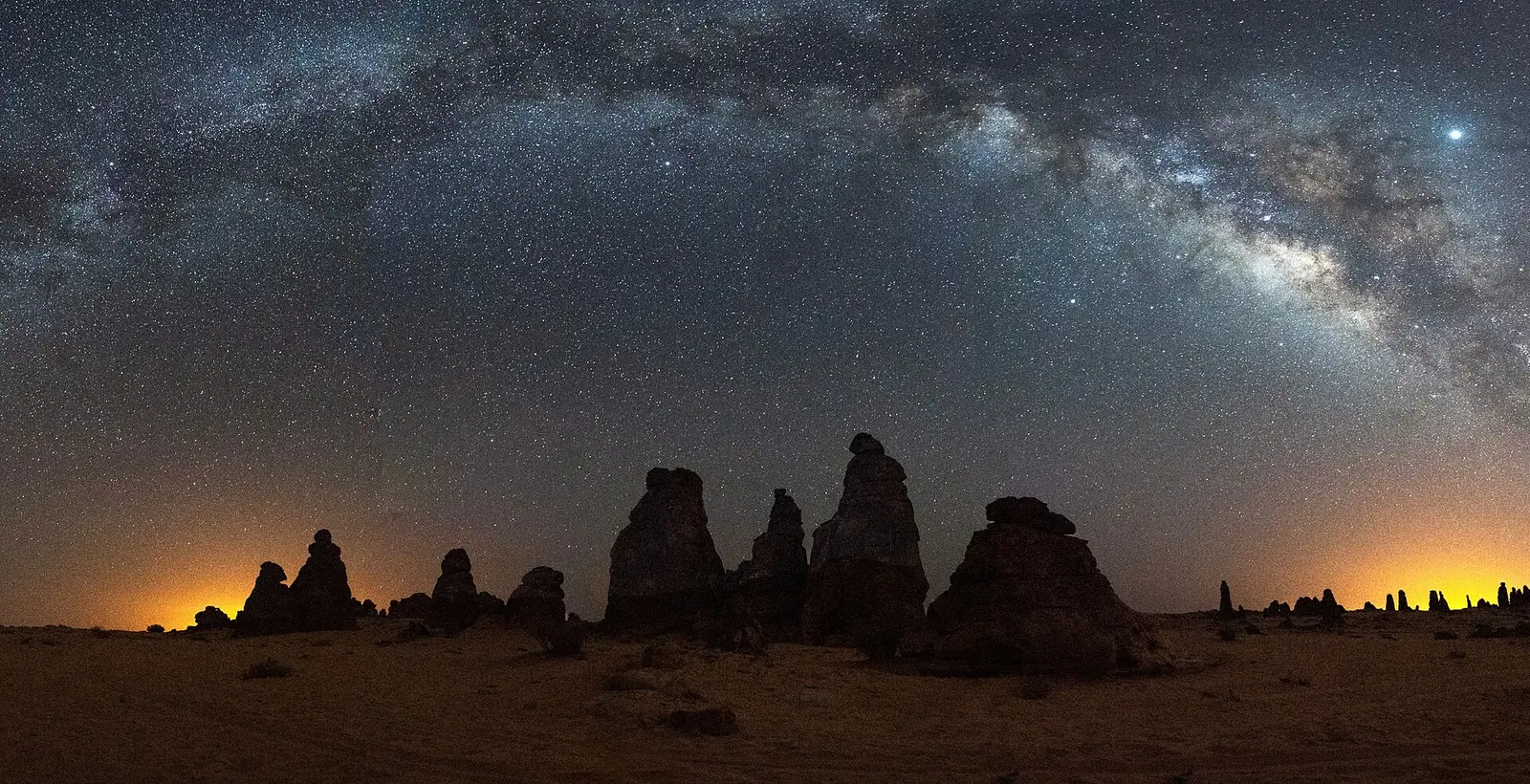 Milky Way over sandstone rock towers at AlUla Manara