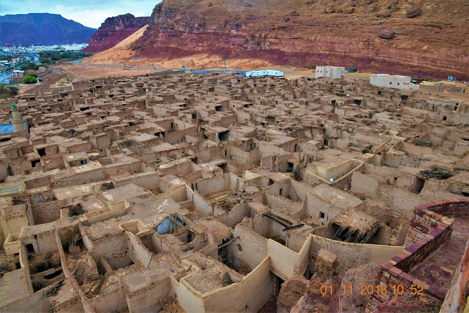 Aerial view of the mud-brick AlUla Old Town with sandstone cliffs behind